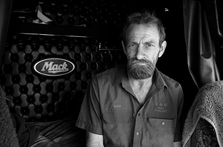 Mack truck driver sitting on his bed 