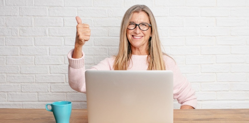 Woman working on laptop and pointing up