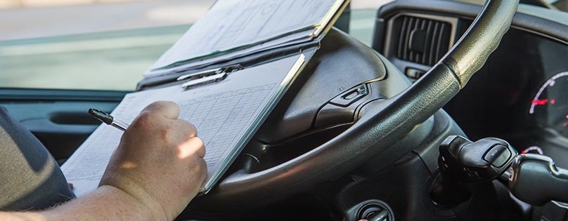 Truck driver keeping track of his hours and miles