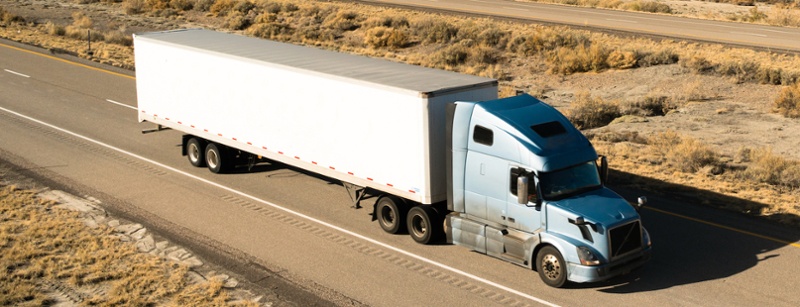 Semi truck driving down an open road