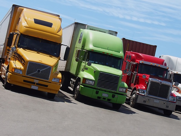 Yellow, green and red semi-trailer trucks